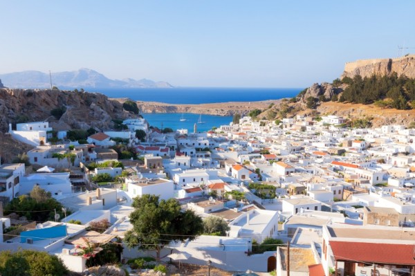 Lindos, Greece. White houses of the village of Lindos, a fortress on the hill and the beautiful bay.